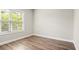 Bedroom with wood-look floors, neutral walls, large window, and white trim at 3657 Atherton Park Ct, Suwanee, GA 30024