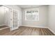 Office with wood-look floors, neutral walls, French doors, large window, and white trim at 3657 Atherton Park Ct, Suwanee, GA 30024