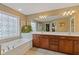 Bathroom featuring double sink vanity, soaking tub, and a unique window at 610 Syemore Pass, Canton, GA 30115