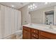 Well-lit bathroom with a double vanity, tile floors, and a shower-tub combination, offering a functional space at 610 Syemore Pass, Canton, GA 30115