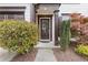 Home entry featuring brown wood door, matching trim, and manicured bushes at 610 Syemore Pass, Canton, GA 30115