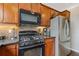 This is a partial view of the kitchen with stainless steel appliances, wood cabinets, and granite countertops at 610 Syemore Pass, Canton, GA 30115