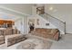Inviting living room with plush sofas, hardwood floors, staircase, and open access to other areas of the house at 610 Syemore Pass, Canton, GA 30115