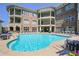 Community pool surrounded by lounge chairs, tables, and lush landscaping at 625 Piedmont Ne Ave # 3029, Atlanta, GA 30308