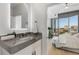 This bright bathroom has a modern vanity, marble countertop, and an illuminated mirror, reflecting the city view at 2795 Peachtree Rd # 1305, Atlanta, GA 30305