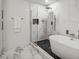 Bathroom featuring a soaking tub, glass shower, and white marble at 2795 Peachtree Rd # 1305, Atlanta, GA 30305