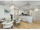 Bright dining room with modern chandelier, table, chairs, kitchen with bar seating, and hardwood floors at 2795 Peachtree Rd # 1305, Atlanta, GA 30305