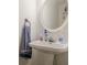 Powder room with pedestal sink, round mirror, and decorative accents at 3403 Spring Harbour Drive Dr, Doraville, GA 30340
