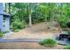 Landscaped backyard with mature trees, a gravel walkway, and a picnic table for outdoor enjoyment at 3531 Evans Ridge Dr, Atlanta, GA 30341