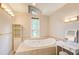 A luxurious bathroom features a soaking tub, vanity, and a large window with backyard views at 3531 Evans Ridge Dr, Atlanta, GA 30341