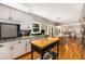 Bright eat-in kitchen with white cabinets, dark backsplash, and view to dining area and living room at 6211 Traymore Se Trce, Smyrna, GA 30082