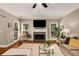 Cozy living room featuring hardwood floors, a fireplace, and large windows for natural light at 6211 Traymore Se Trce, Smyrna, GA 30082