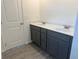 Bathroom featuring a gray double vanity with white countertops and stylish gray cabinets, complemented by wood-look flooring at 777 Oakmont Trce, Canton, GA 30114