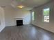 Open living room with hardwood floors features a gas fireplace and two windows to let in light at 777 Oakmont Trce, Canton, GA 30114