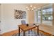 Bright office space features a modern chandelier, hardwood floors, and natural light from a large window at 1240 Oakland Sw Ter # B, Atlanta, GA 30310