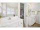 Bright bathroom featuring dual sinks, a large mirror, and a glimpse into the bedroom at 130 White Sands Ct, Suwanee, GA 30024