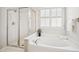 Modern bathroom showcases a glass-enclosed shower and separate soaking tub under a window at 130 White Sands Ct, Suwanee, GA 30024