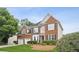 Charming brick home with blue shutters, lush landscaping, and a well-manicured lawn at 130 White Sands Ct, Suwanee, GA 30024