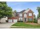 Beautiful two-story brick home featuring a two-car garage and lush green landscaping at 130 White Sands Ct, Suwanee, GA 30024