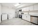 Bright kitchen features white cabinets, stainless steel appliances, washer and dryer at 130 White Sands Ct, Suwanee, GA 30024