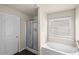 Bright bathroom featuring a shower, soaking tub, and a window with blinds at 133 Worthing Ln, Fairburn, GA 30213