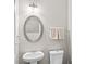 Elegant powder room with oval mirror, pedestal sink and neutral decor at 133 Worthing Ln, Fairburn, GA 30213