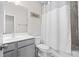 Neutral toned bathroom with a shower, toilet, vanity, and matching gray cabinets at 490 Duval Dr, Alpharetta, GA 30009