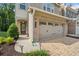 Attractive brick townhome featuring a spacious two-car garage and a welcoming front entrance at 490 Duval Dr, Alpharetta, GA 30009