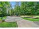 Community playground featuring swings, slides, and a bench for relaxation amidst a serene wooded setting at 490 Duval Dr, Alpharetta, GA 30009
