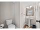 Well-lit powder room with a pedestal sink, decorative mirror, and modern fixtures showcasing simple elegance at 490 Duval Dr, Alpharetta, GA 30009