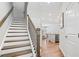 Elegant staircase leading to an open-concept living area with hardwood floors at 490 Duval Dr, Alpharetta, GA 30009