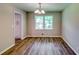 Bright dining room featuring hardwood floors, a chandelier, and natural light from the window at 3755 Greentree Dr, Decatur, GA 30032