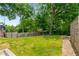 Lush backyard with a large grassy area, mature trees, and a wooden fence for privacy at 417 E College Ave # 302, Decatur, GA 30030