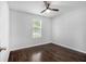 A clean bedroom with hardwood floors, a ceiling fan, and a window allowing natural light at 4835 Kellys Mill Nw Dr, Lilburn, GA 30047