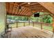 Covered back porch features ceiling fans, a TV, and a wood-paneled ceiling at 4835 Kellys Mill Nw Dr, Lilburn, GA 30047