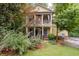Charming two-story home featuring a welcoming front porch and second story balcony, surrounded by lush greenery at 635 Holcomb Bridge Rd, Norcross, GA 30071