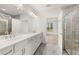 Bright bathroom with double vanity, a glass-enclosed shower, and neutral tiling at 1649 Tielman Way, Snellville, GA 30078