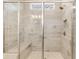 Modern bathroom shower with glass door, neutral stone tiling, and built-in bench at 1649 Tielman Way, Snellville, GA 30078