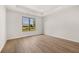 Sunlit bedroom featuring a large window, hardwood flooring, and a tray ceiling at 1649 Tielman Way, Snellville, GA 30078