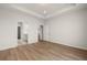 Large bedroom featuring hardwood floors, tray ceiling and access to the en suite bathroom at 1649 Tielman Way, Snellville, GA 30078