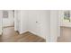 Hallway with neutral paint and wood-look flooring; doors lead to additional rooms at 1649 Tielman Way, Snellville, GA 30078