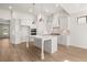 Open kitchen boasts white cabinets, stainless steel appliances, and a large center island at 1649 Tielman Way, Snellville, GA 30078