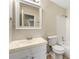 Well-lit bathroom with a vanity, toilet, and shower-tub combo with white accents at 3227 Ivy Lake Ct, Buford, GA 30519