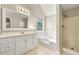 Bright bathroom featuring dual shower heads, tub, and vanity with ample storage at 3227 Ivy Lake Ct, Buford, GA 30519