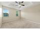Cozy bedroom featuring tray ceiling, neutral carpet, and abundant natural light at 3227 Ivy Lake Ct, Buford, GA 30519