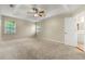Open main bedroom featuring tray ceiling, neutral carpet, and a view to the bath at 3227 Ivy Lake Ct, Buford, GA 30519