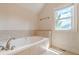 Bright bathroom featuring a large soaking tub with tile surround and a window providing natural light at 3404 Orchard St, Hapeville, GA 30354
