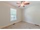 This bedroom features neutral carpet, a ceiling fan, and a window at 3404 Orchard St, Hapeville, GA 30354