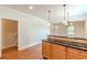 Open kitchen featuring wood cabinets, black countertop and view to entrance door at 3404 Orchard St, Hapeville, GA 30354