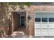 Inviting entryway with a brick facade, well-lit porch, and garage access at 433 The North Chace, Atlanta, GA 30328